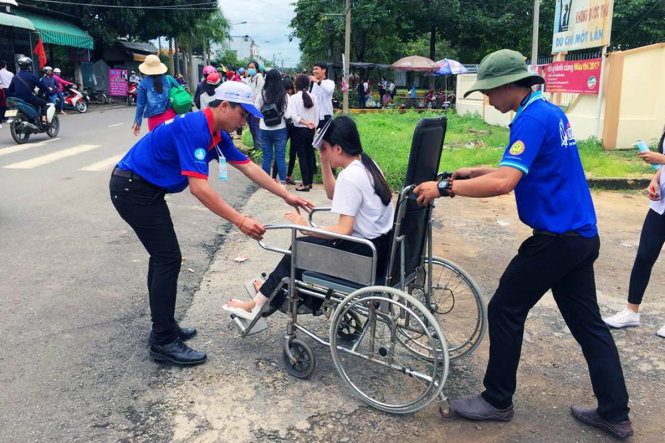 Sinh viên tình nguyện hỗ trợ một thí sinh bị gãy chân tại hội đồng thi Trường THPT Tân Phú (huyện Định Quán, Đồng Nai) - Ảnh: A LỘC