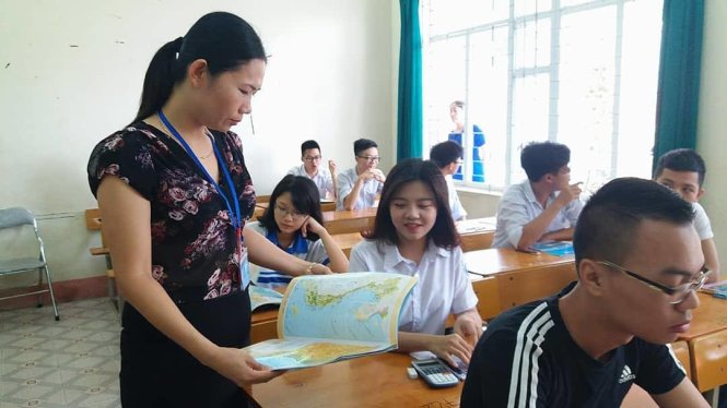 Giám thị tại điểm thi trường THPT Văn Lang (TP Hạ Long) kiểm tra Át lát địa lý của các em - Ảnh: Đức Hiếu