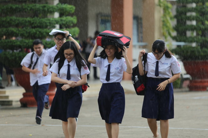 Ra về trong cơn mưa sau khi thi xong môn tiếng Anh, các thí sinh tại điểm thi Trường THPT Phú Nhuận (TP.HCM) cho biết đề tiếng Anh năm nay vừa sức - Ảnh: NHƯ HÙNG