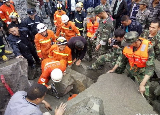 Vụ sạt lở tạo ra hàng tấn đá bên dưới khiến lực lượng cứu hộ rất vất vả khi tìm cứu người - Ảnh: People's Daily/TW