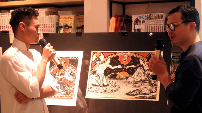 Họa sĩ Tạ Huy Long (phải) đang giới thiệu bức tranh vẽ truyện Hồng Bàng - một trong các tác phẩm anh ưng ý nhất trong Lĩnh Nam Chích Quái - Ảnh: L.Điền