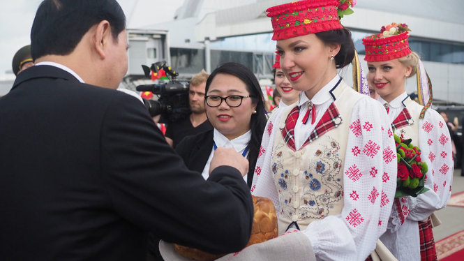 Các thiếu nữ Belarus trong trang phục truyền thống mời Chủ tịch nước Trần Đại Quang thưởng thức bánh mì với muối theo nghi thức truyền thống đón nguyên thủ nước ngoài của nước này - Ảnh: QUỲNH TRUNG
