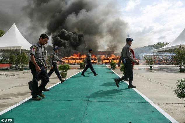 Cảnh sát Myanmar đi bộ gần nơi đốt ma túy - Ảnh: AFP