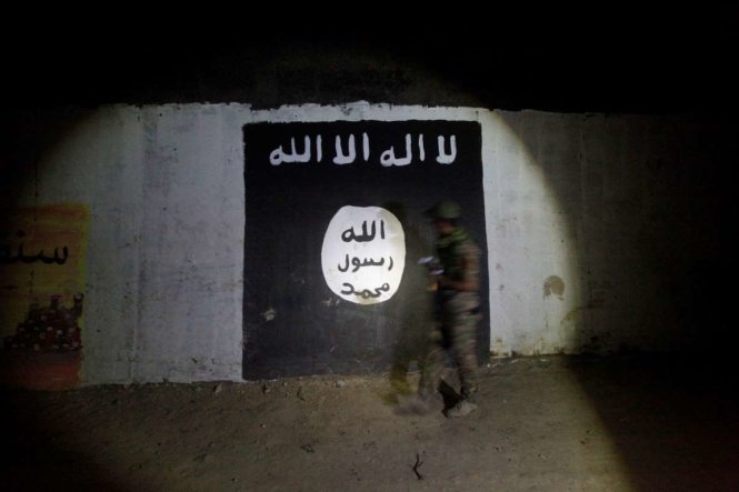 Các khẩu hiệu bằng tiếng Ả rập của IS sơn trên bức tường của khu vực hầm được chúng sử dụng làm doanh trại huấn luận trên một sườn đồi trông ra thành phố Mosul của Iraq - Ảnh: Reuters