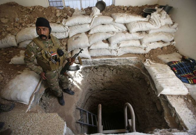Một quân nhân Iraq đứng cạnh lối vào đường hầm từng thuộc về IS ở huyện Talkeef, phía bắc thành phố Mosul , Iraq - Ảnh: Reuters