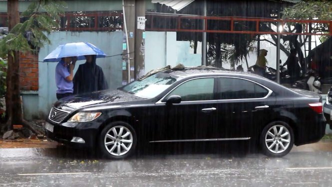 Lực lượng chức năng đội mưa khám nghiệm ôtô - Ảnh: Nghi Sơn