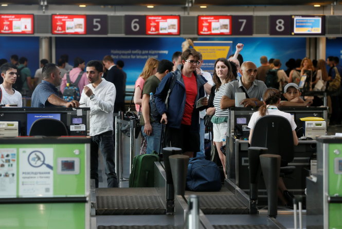 Hành khách đứng ngồi không yên do hệ thống quản lý ở sân bay Boryspil, ở ngoại ô thủ đô Kiev của Ukraine, bị tấn công ngày 27-6 - Ảnh: Reuters