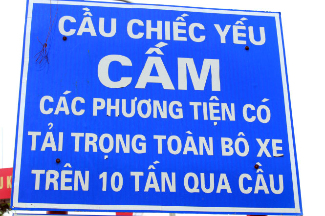 Do cầu xuống cấp nghiêm trọng, công ty cổ phần quản lý và xây dựng đường bộ I - Hà Tây đã phải gia cường mặt cầu bằng tấm đan sắt thép, sau đó sở GTVT Hà Nội cũng đã cắm biển báo cấm xe trọng tải quá 10 tấn lưu thông qua cầu. ảnh : Chí Tuệ