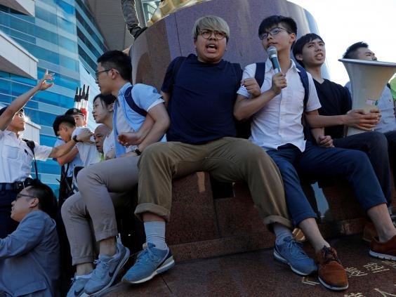 Nhà hoạt động vì dân chủ Hoàng Chi Phong hô vang khẩu hiệu tại tượng đài Golden Bauhinia - Ảnh: Reuters