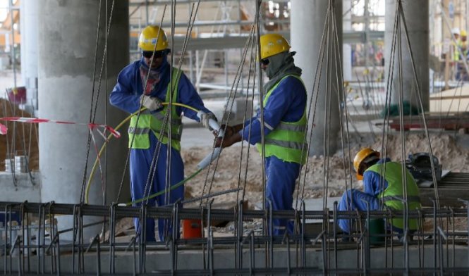 Các công nhân nhập cư đang làm việc trên một công trường xây dựng tại Doho, Qatar - Ảnh: AFP