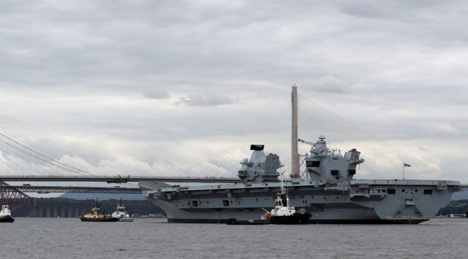 Tàu sân bay HMS Queen Elizabeth được lai dắt ra khỏi cảng chuẩn bị chuyến đi biển thử nghiệm ngày 26-6 - Ảnh: Reuters