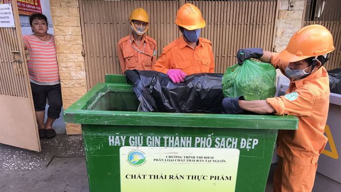 Công nhân thu gom rác thực phẩm (đã phân loại) tại hẻm 25 Nguyễn BỈnh Khiêm, Q.1 - Ảnh: Q.KHẢI