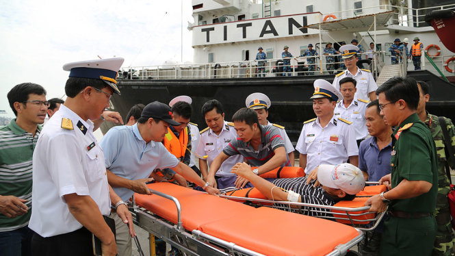 Bệnh nhân Lại đang được đưa từ trên tàu xuống cầu cảng - Ảnh: QUANG TIẾN