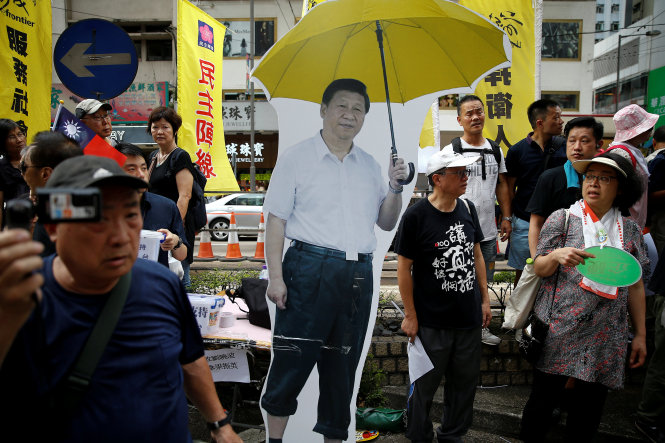 Hình ảnh ông Tập cầm dù xuất hiện trong cuộc biểu tình. Chiếc dù màu vàng được xem là biểu tượng của cuộc biểu tình chiếm khu Trung Hoàn cách đây 3 năm - Ảnh: Reuters