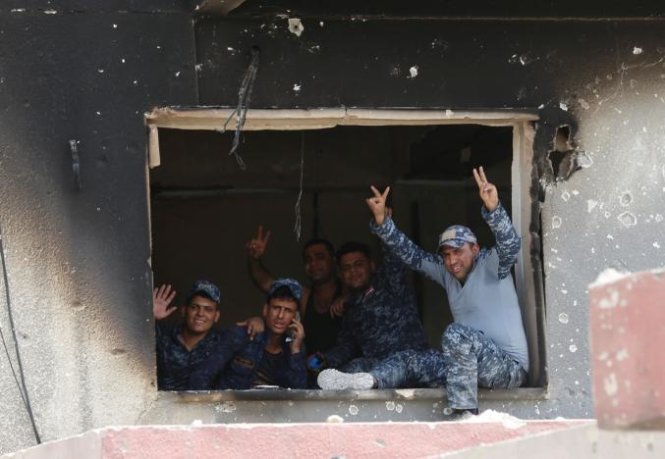 Các thành viên thuộc lực lượng cảnh sát liên bang ra ký hiệu chiến thắng khi tham gia cuộc chiến chống các phiến quân IS tại thành cổ Mosul, Iraq ngày 3-7 - Ảnh: Reuters