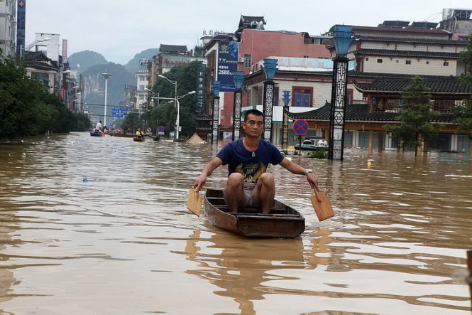 Người dân bơi xuồng đi trên đường ở thành phố Liễu Châu, tỉnh Quảng Tây, Trung Quốc - Ảnh: REUTERS