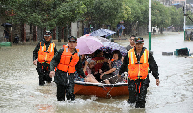 Nhân viên cứu hộ sơ tán người dân ở quận Xiushui, tỉnh Giang Tây - Ảnh: REUTERS