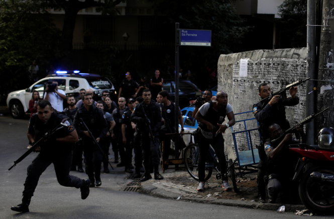 Người dân hiếu kỳ tụ tập xem một vụ đấu súng của cảnh sát với băng đảng ma túy ở Brazil - Ảnh: Reuters