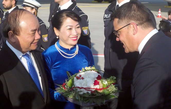 Bộ trưởng Khoa học và Nghệ thuật bang Hessen ông Boris Rhein tặng hoa cho Thủ tướng Nguyễn Xuân Phúc và Phu nhân tại sân bay quốc tế Frankfurt sáng 5-7 giờ địa phương - Ảnh: Quỳnh Trung