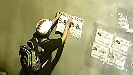 Một thanh niên dán tờ rơi lên tường nhà người dân ở P.Phước Long B, Q.9, TP.HCM bị camera an ninh ghi lại