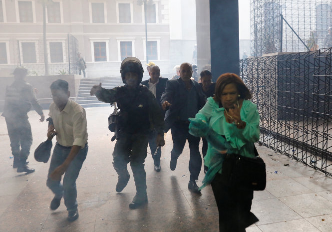 Lực lượng an ninh giúp di tản người trong quốc hội - Ảnh: Reuters