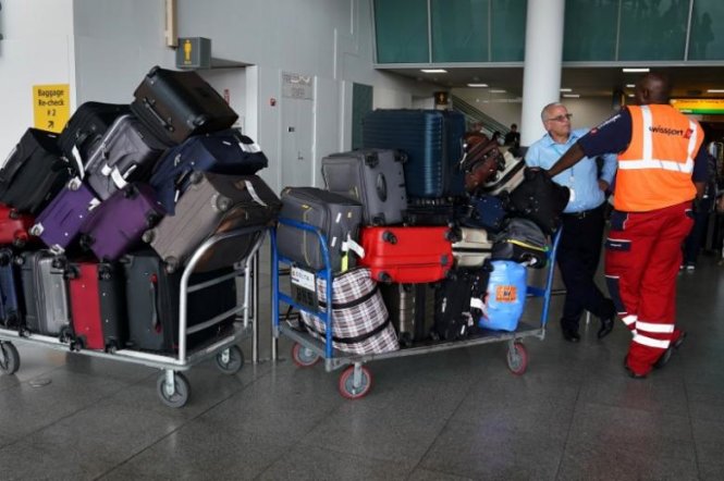 Nhân viên bốc xếp hành lý tại sân bay John F. Kennedy ở thành phố New York, Mỹ - Ảnh: Reuters