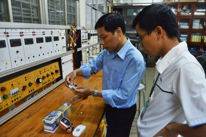 Tiến sĩ Nguyễn Quang Nam - phó trưởng khoa điện - điện tử Trường đại học Bách khoa TP.HCM - tháo và phân tích hai thiết bị tiết kiệm điện - Ảnh: Lê Phan