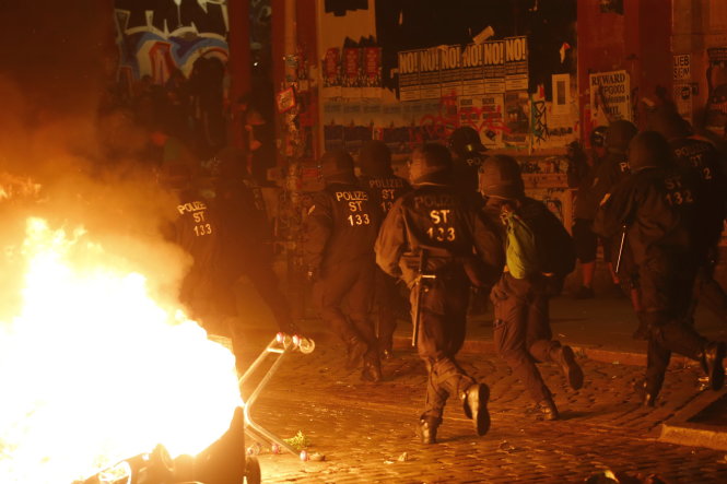 Cảnh sát chống bạo động tấn công giải tán nhóm biểu tình quá khích - Ảnh: Reuters