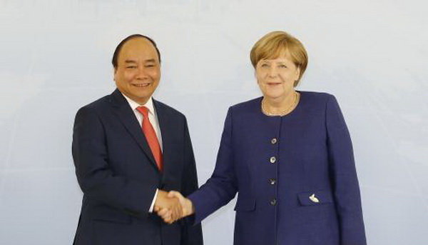 Thủ tướng Nguyễn Xuân Phúc bắt tay với Thủ tướng Angela Merkel tại Hamburg tối 6-7 giờ địa phương. Ảnh: TTXVN