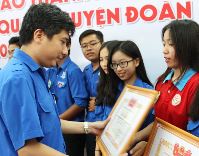 Phó bí thư Thành đoàn Nguyễn Việt Quế Sơn (bìa trái) trao khen thưởng cho các Đoàn trường hoạt động xuất sắc - Ảnh: Q.L.