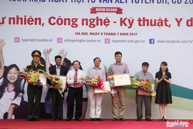 Thứ trưởng Bộ GD-ĐT Bùi Văn Ga (thứ 3 từ trái sang) tặng bằng khen và hoa cho các thành viên của Ban tư vấn của ngày hội tư vấn xét tuyển ĐH, CĐ 2017 - Ảnh: Nguyễn Khánh