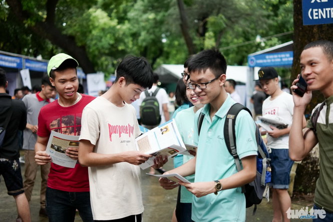 Các bạn học sinh tiếp nhận thông tin tuyển sinh của các trường ĐH, CĐ thông qua các tờ rời được các trường ĐH, CĐ gửi tặng - Ảnh: Nguyễn Khánh
