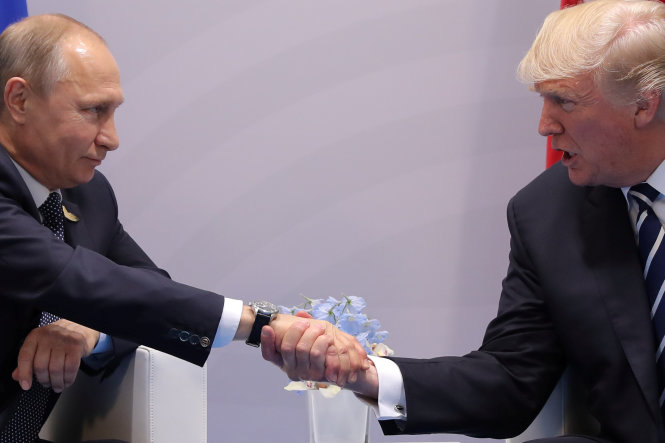 Tổng thống Nga Vladimir Putin (trái) bắt tay Tổng thống Mỹ Donald Trump (phải) trong cuộc gặp trực tiếp đầu tiên ngày 7-7 - Ảnh: Reuters