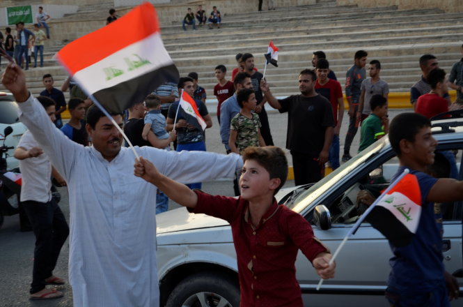 Người dân ở Mosul vẫy cờ mừng thoát khỏi bọn IS - Ảnh: Reuters