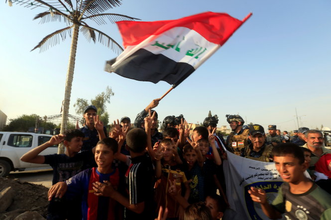 Trẻ em ở Mosul ra đường ăn mừng thành phố giải phóng cùng các tay súng chính phủ vào ngày 9-7 - Ảnh: Reuters