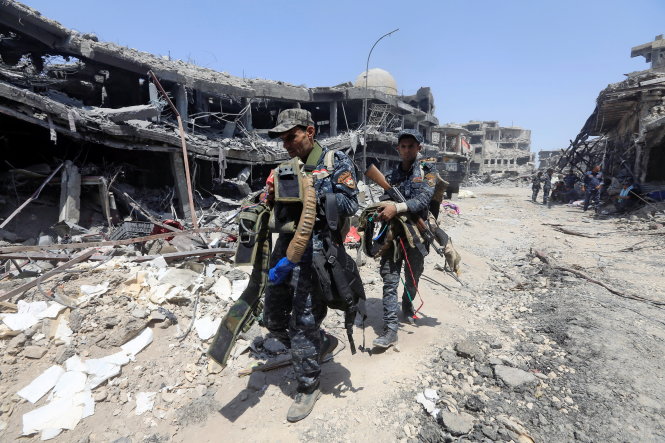 Binh sĩ Iraq thu gom các đai bom tự sát của bọn IS bỏ lại ở Mosul - Ảnh: Reuters