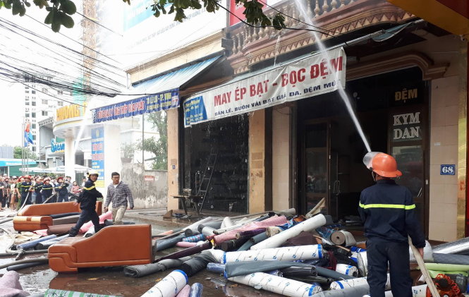 Lính cứu hỏa đang dập lửa trên tầng 2 và 3 của ngôi nhà số 68 Lê Lợi, TP.Vinh - Ảnh: Doãn Hòa