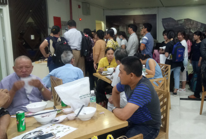 Hành khách xếp hàng lấy phần ăn ở nhà hàng Hoa Mai sau khi máy bay trễ chuyến - Ảnh: Trần Kiêm Hạ