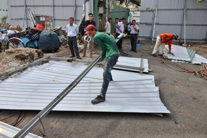 Các công nhân đang rào chắn lô cốt để tiến hành tháo dỡ các căn nhà còn lại - Ảnh: Lê Phan