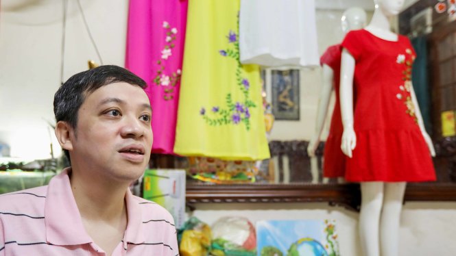 Anh Nguyễn Bảo Sơn bên những mẫu áo thêu của mình - Ảnh: Việt Dũng