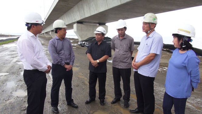 Thứ trưởng Bộ GTVT Nguyễn Văn Công (thứ 2 từ trái sang) nghe nhà thầu thông tin thêm về việc khắc phục những khiếm khuyết của công trình dự án đường ô tô Tân Vũ - Lạch Huyện - Ảnh: NGUYÊN NGỌC