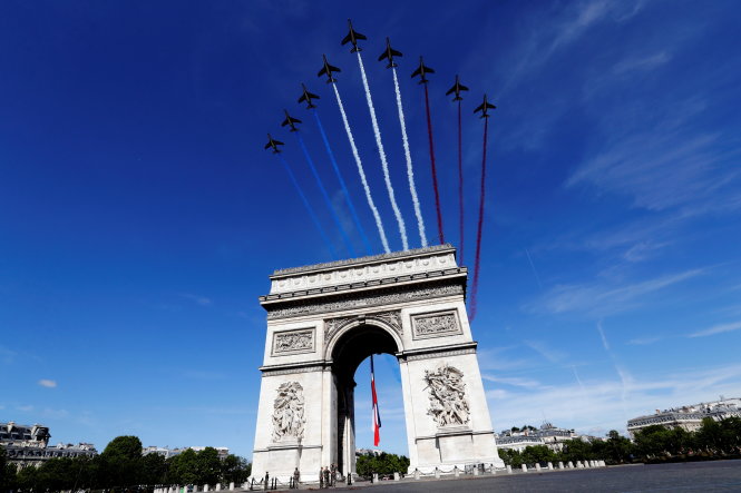 Máy bay chiến đấu thả khói màu cờ Pháp xanh - trắng - đỏ phía trên Khải Hoàn Môn - Ảnh: Reuters