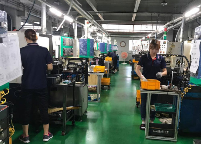 Công nhân Việt Nam đứng máy tiện ở một xưởng sản xuất tại Busan, Hàn Quốc - Ảnh: MAI NHÂN