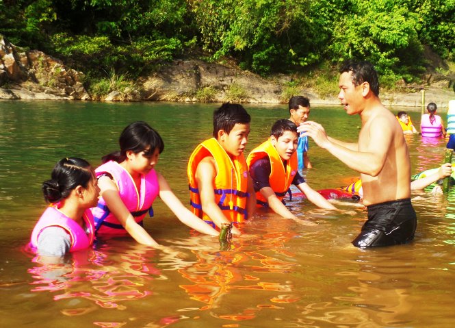 Thầy giáo hướng dẫn học trò cách thở nước và bơi trên sông - Ảnh: TRẦN MAI