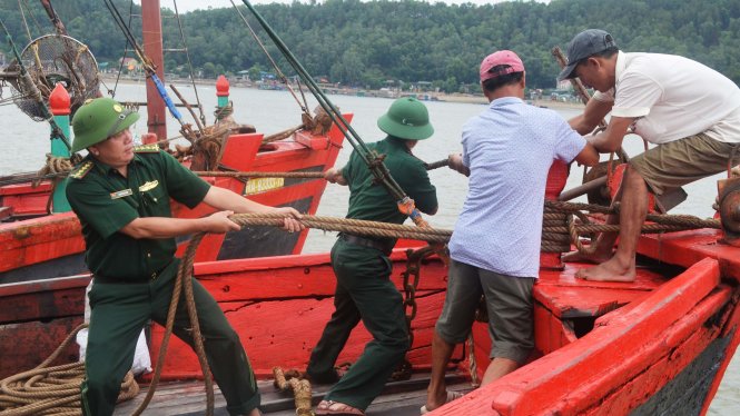 Lực lượng Bộ đội biên phòng Nghệ An hỗ trợ ngư dân chằng chống tàu thuyền trú bão chiều 16-7 - Ảnh: DOÃN HÒA