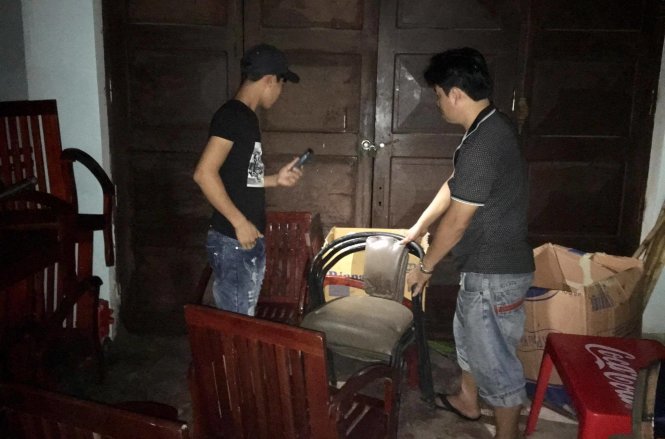 Chủ một khách sạn trên đường Bình Minh, TX Cửa Lò dùng ghế chắn cửa lúc 21h40 tối 16-7 vì gió giật mạnh - Ảnh: DOÃN HÒA
