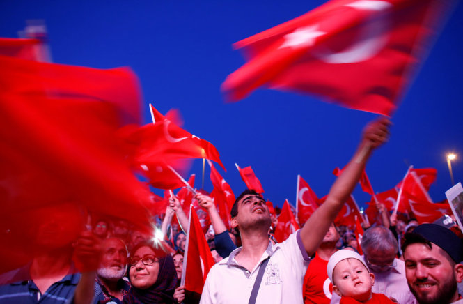 Người dân vẫy cờ trong cuộc diễu hành kỷ niệm cuộc đảo chính thất bại ở Istanbul - Ảnh: Reuters