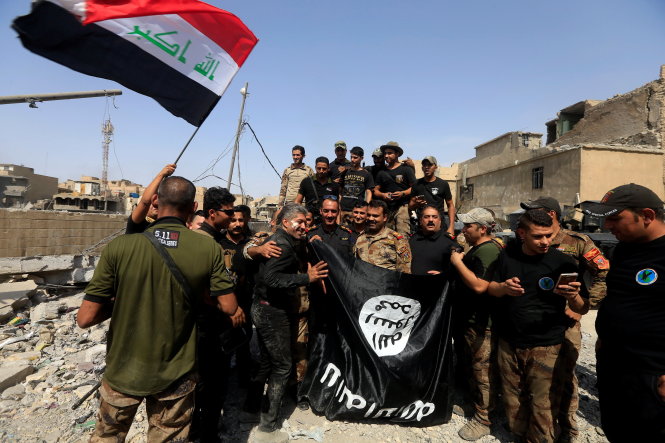 Những người lính chống khủng bố chụp hình kỷ niệm với lá cờ IS sau khi tái chiếm Mosul ngày 9-7-2017 - Ảnh: Alaa Al Marjani/Reuters