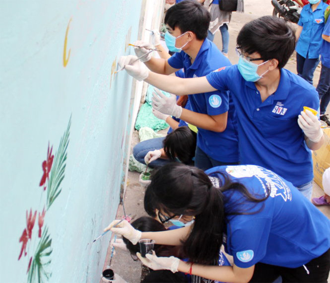 Chiến sĩ Mùa hè xanh vẽ trang trí tường khu cư xá cũ tại đường Khánh Hội (Q.4, TP.HCM) - Ảnh: Q.L.