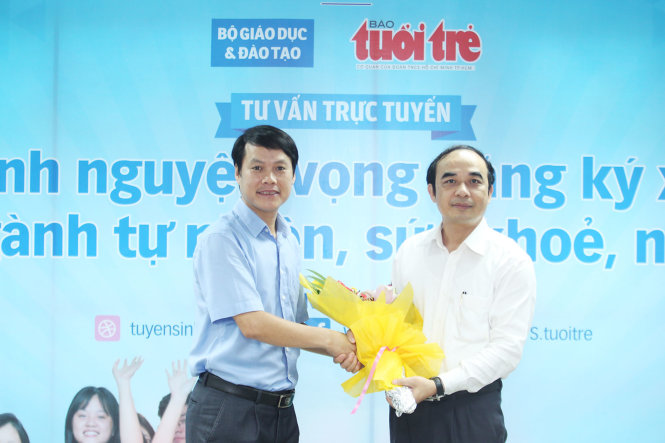 Đại diện báo Tuổi Trẻ (trái) tặng hoa cho GS Nguyễn Hữu Tú, phó hiệu trưởng trường ĐH Y Hà Nội - Ảnh: Nguyễn Khánh